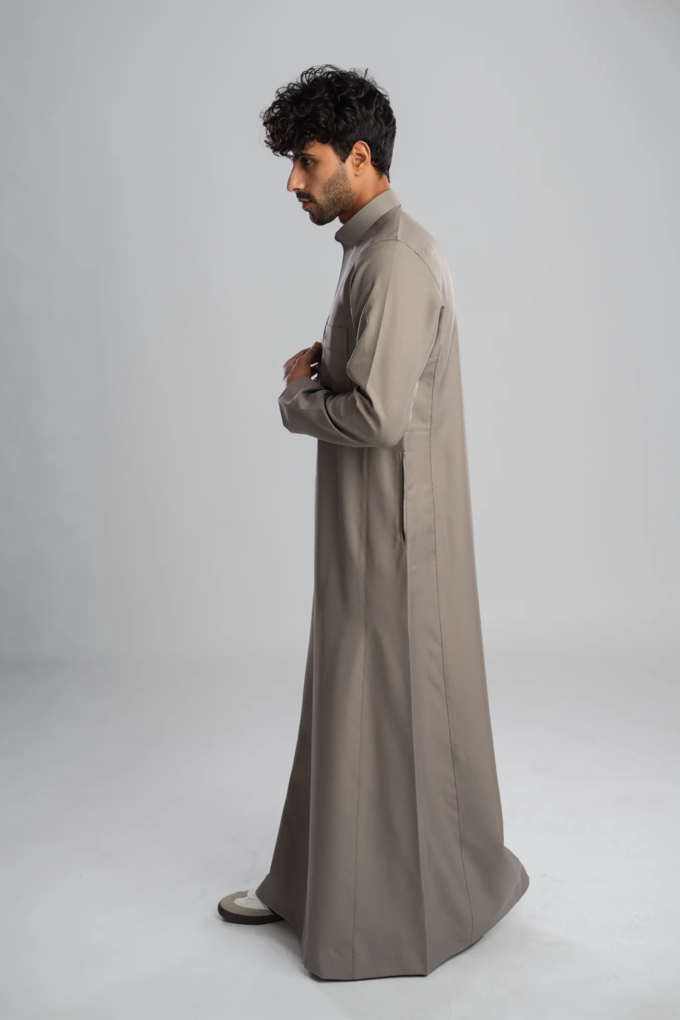 Traditional gray men's thobe in profile, full length.