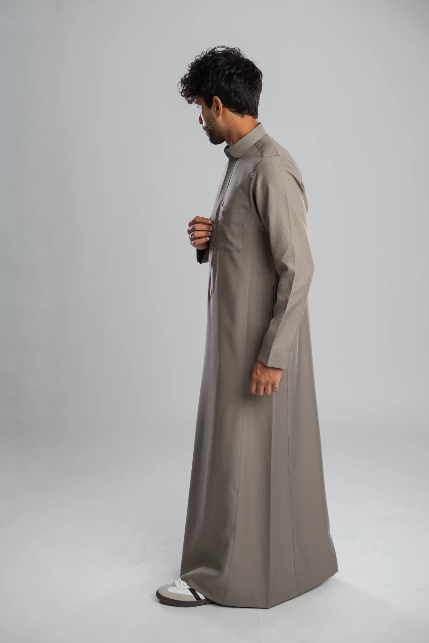 Traditional gray men's thobe in profile, full length.